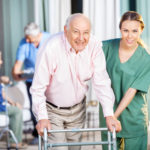 Ritratto dell operatrice oss femminile felice che aiuta uomo anziano nella casa di cura